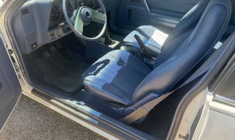 Drivers seat with the door open. The seat and dashboard are blue.
