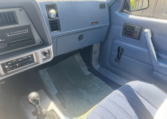 Passenger blue dashboard and part of the center showing a glovebox, heat controls, radio controls, and the passenger blue door panel.