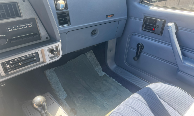Passenger blue dashboard and part of the center showing a glovebox, heat controls, radio controls, and the passenger blue door panel.